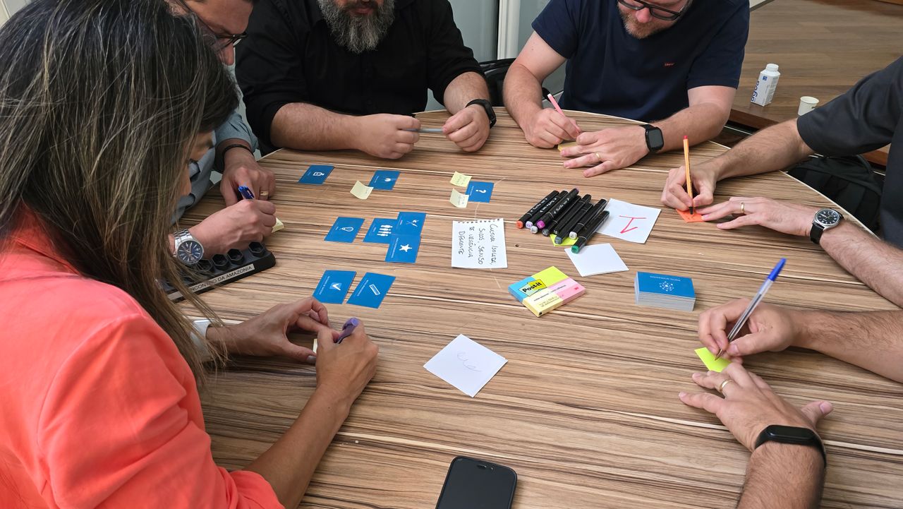 Sinnvoll Diverse team engaged in a brainstorming session with cards and sticky notes on a round table.